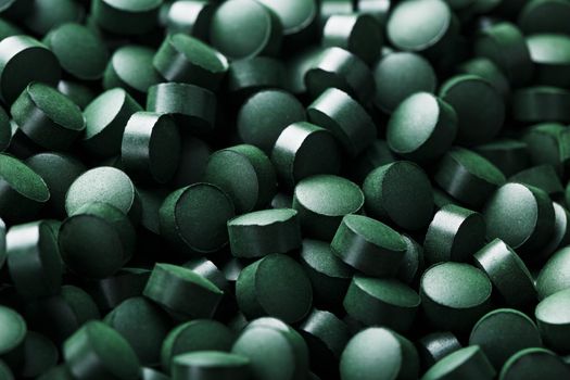 Green tablets from spirulina vegetarian dietary supplement as a full-screen texture