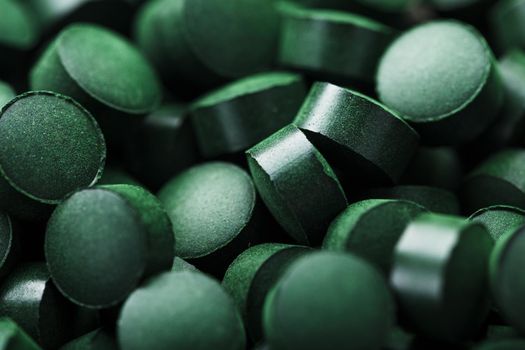 Green tablets from spirulina vegetarian dietary supplement as a full-screen texture