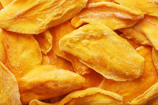 Pieces of sweet dried mango close-up as a background in full screen top view