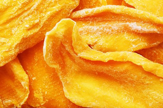 Pieces of sweet dried mango close-up as a background in full screen top view