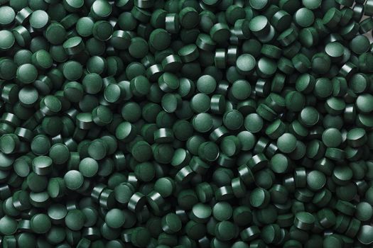 Green tablets from spirulina vegetarian dietary supplement as a full-screen texture