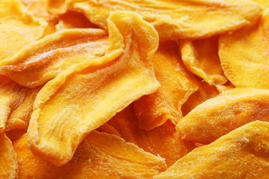 Pieces of sweet dried mango close-up as a background in full screen top view