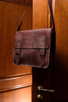 brown leather briefcase with antique and retro looks for man. indoor photo