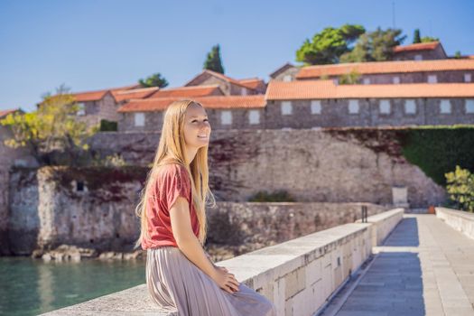 Woman tourist on background of beautiful view of the island of St. Stephen, Sveti Stefan on the Budva Riviera, Budva, Montenegro. Travel to Montenegro concept.