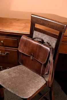 brown leather briefcase with antique and retro looks for man. indoor photo