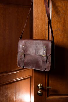 brown leather briefcase with antique and retro looks for man. indoor photo