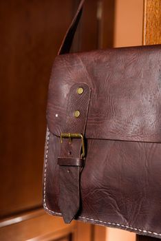 brown leather briefcase with antique and retro looks for man. indoor photo