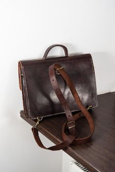 brown leather briefcase with antique and retro look for man. indoor photo