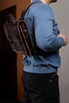 Back of man with brown leather backpack. Unisex bag for sale. Unbranded backpack.