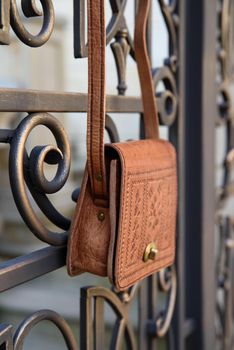 small yellow women's leather bag with a carved pattern. street photo