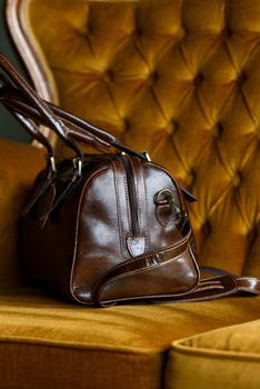 close-up photo of brown leather bag on a vintage sofa. indoor photo