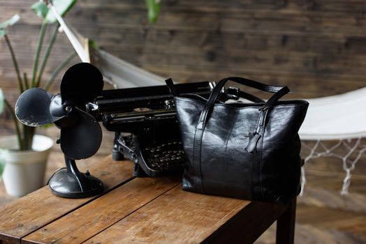 close-up photo of black leather bag on a wooden table. indoor photo
