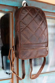 Brown leather backpack on the window.