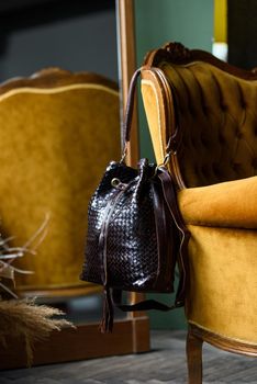 brown leather backpack on the vintage armchair.