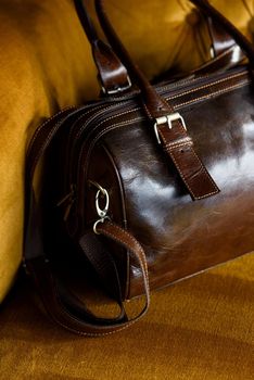 close-up photo of brown leather bag on a vintage sofa. indoor photo