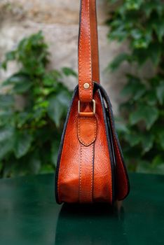 small orange women's leather bag . street photo