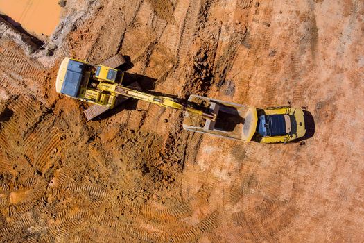 Top aerial view of excavator truck are loading soil a dump truck