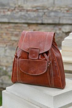 Orange leather backpack on the snone monument.