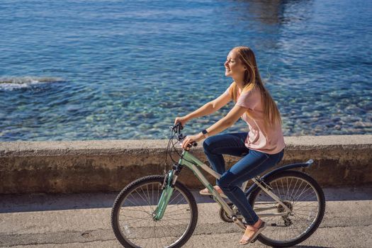 Woman tourist on a bicycle explores Budva in Montenegro. Cycling in Montenegro concept.