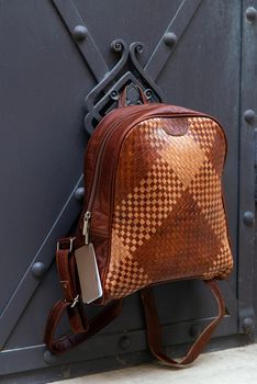 Brown leather backpack with a pattern. Street photo