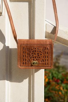 small yellow women's leather bag with a carved pattern. street photo