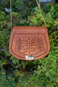 small yellow women's leather bag with a carved pattern. street photo