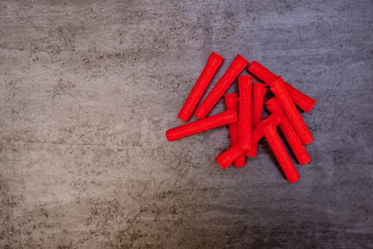 Red plastic dowels on grey background.