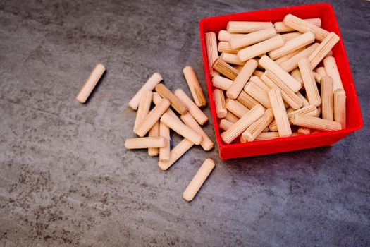 View of a grouping of wooden dowels on grey background. Close-up.