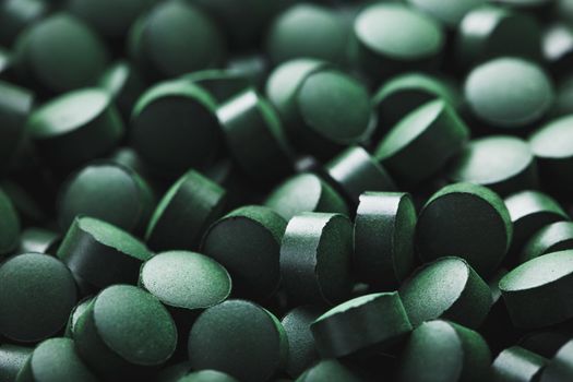 Close-up of Green tablets of organic spirulina as a texture background macro in full screen