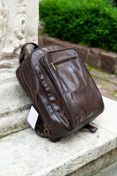 Brown leather backpack on the snone monument.