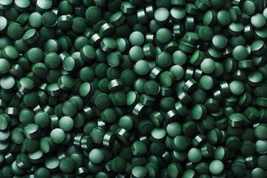 Green tablets from spirulina vegetarian dietary supplement as a full-screen texture