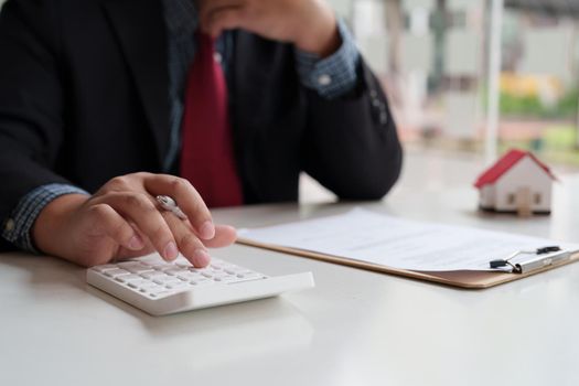 Businessman doing finances and calculate about cost to real estate investment