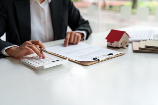 Business Financing Accounting Banking Concept, business woman doing finances and calculate about cost to real estate investment and in other, tax system.