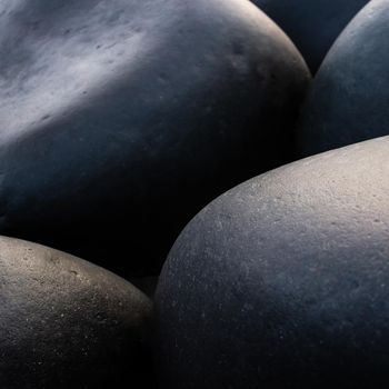 Big black pebble stones background, square