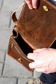 close-up photo of orange leather messanger bag. outdoors photo.