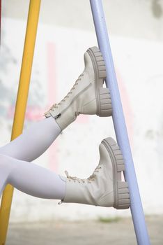 Female legs wearing white fashion boots with laces.