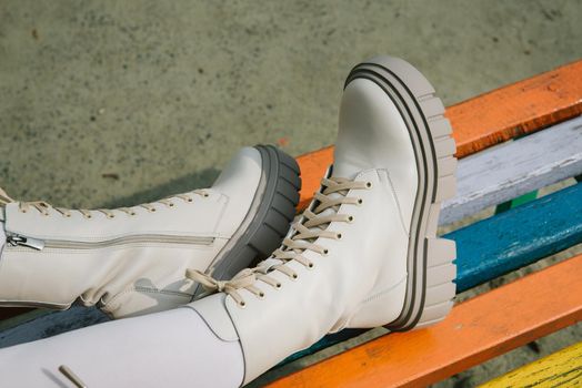 Female legs wearing white fashion boots with laces.