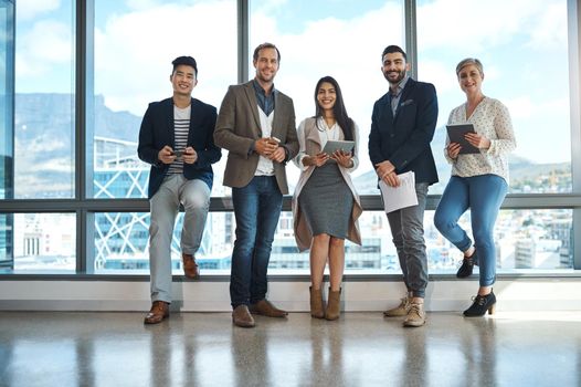 Portrait of a diverse group of businesspeople using wireless technology in an office.