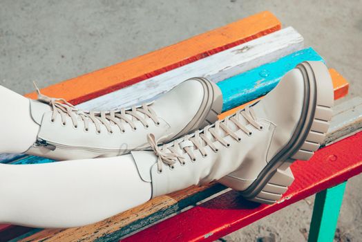 Female legs wearing white fashion boots with laces.