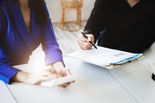 negotiation, analysis, discussion,asian male economist pointing out a document explaining the investment finance program to the company owner to plan marketing and hedging business risks