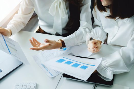 Consulting, learning, marketing, investment, finance, data analysis, research, two Asian women holding papers, sitting and analyzing financial statements and using computers at work