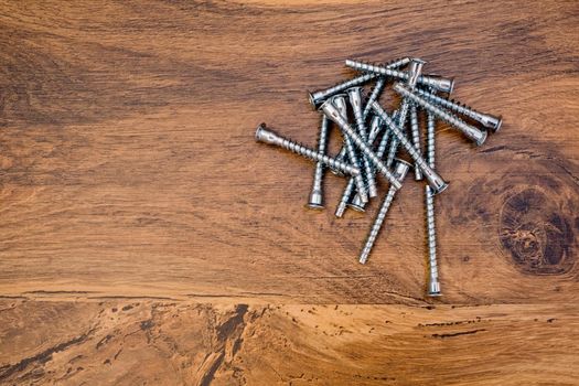 Close up of hex bolts screw for furniture assembly on wooden background. Top view.