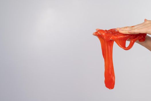 Red slime flowing down from a woman's hand on a white background