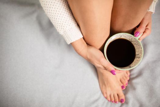 European light complexion. Coffee in a porcelain cup. Feminine hands with pink nail polish. Love for coffee and relaxation.