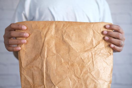 holding a a lunch paper packet close up ,