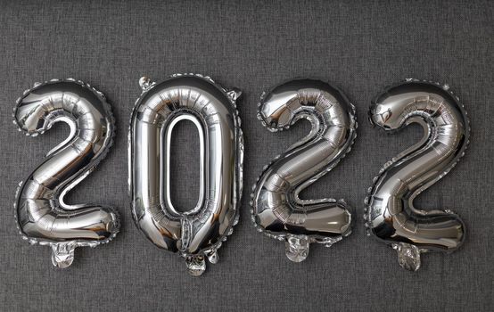 new year 2022 shiny silver balloons on grey background. High quality photo