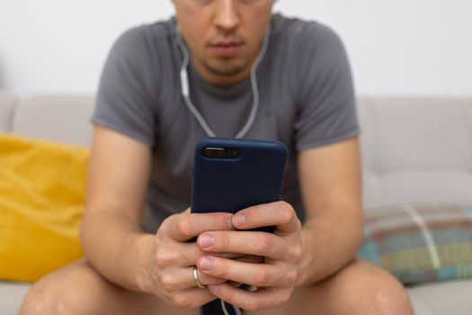young man in headphones watching at mobile phone. High quality photo