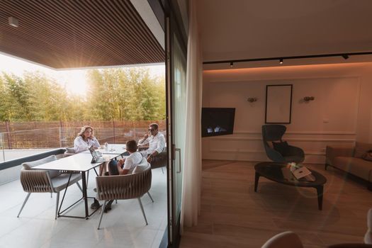 An elderly couple enjoys the terrace of a luxury house with their son during the holidays. Selective focus. High-quality photo