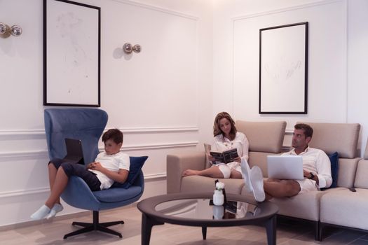 A modern family enjoys a vacation in their luxury home. The family spends time on modern devices, tablets, and laptops. Selective focus. High-quality photo