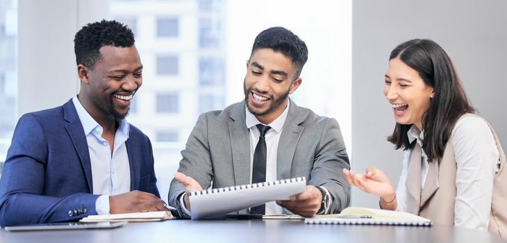 Shot of a team of business people reading through documents during a meeting.